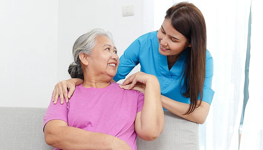 Healthcare provider examining senior woman's shoulder showing professional medical care and support